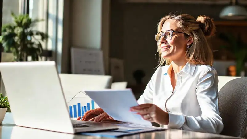 Una mujer optimista gestiona finanzas digitalmente