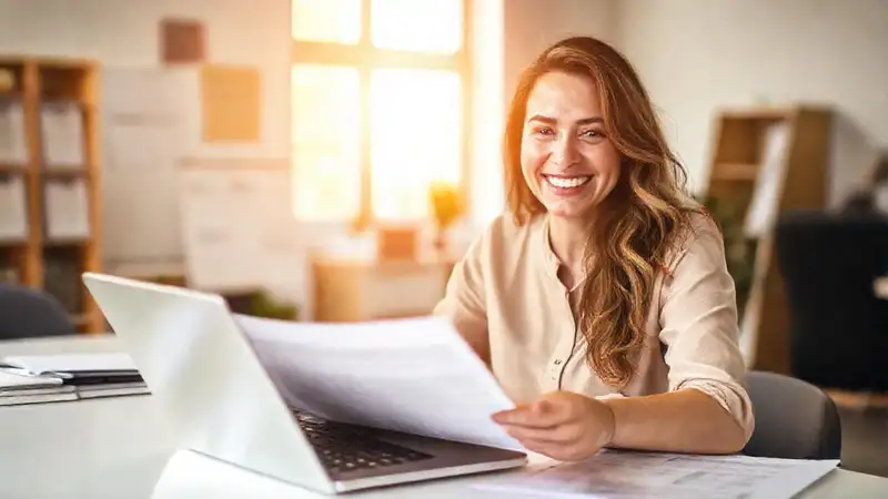 Mujer sonríe resolviendo trámites fiscales digitalmente